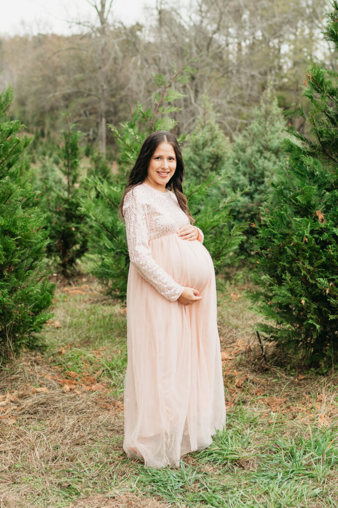 A cozy tree farm family photography session in Georgia, featuring a family posing among lush evergreens during golden hour.
