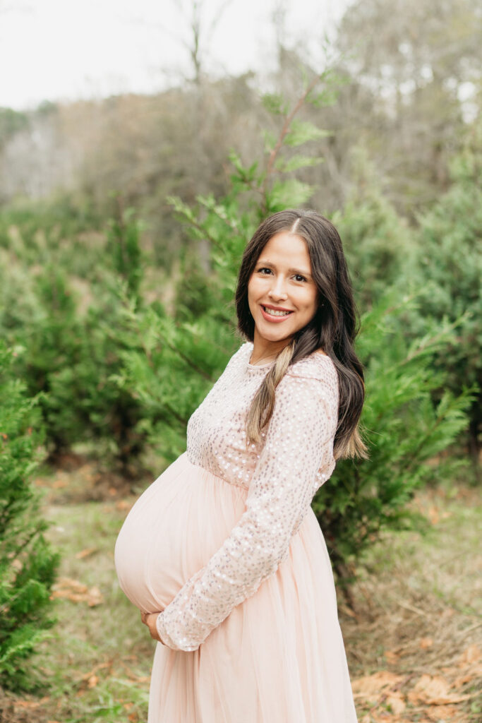 A cozy tree farm family photography session in Georgia, featuring a family posing among lush evergreens during golden hour.