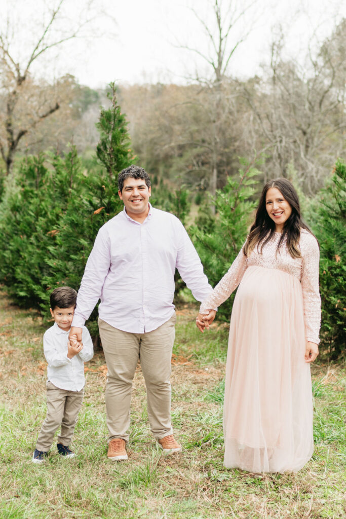 Heartwarming candid moments from a tree farm family session in Georgia, capturing laughter and love in a rustic outdoor setting