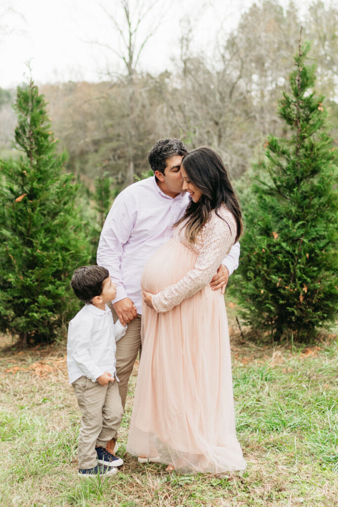 Heartwarming candid moments from a tree farm family session in Georgia, capturing laughter and love in a rustic outdoor setting