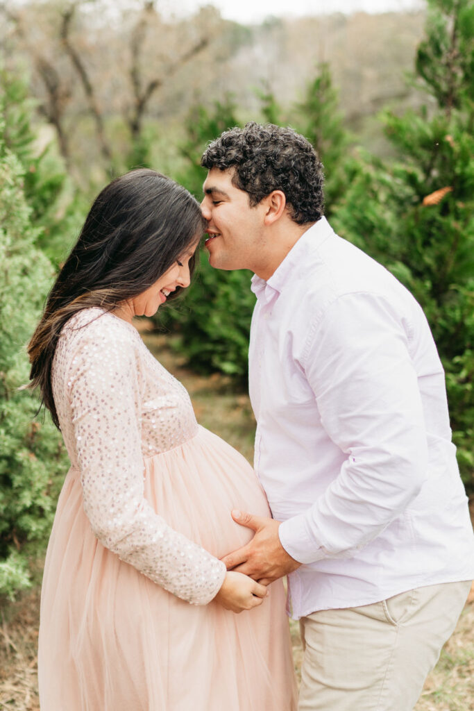 A cozy tree farm family photography session in Georgia, featuring a family posing among lush evergreens during golden hour.
