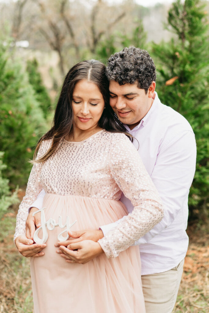 Heartwarming candid moments from a tree farm family session in Georgia, capturing laughter and love in a rustic outdoor setting