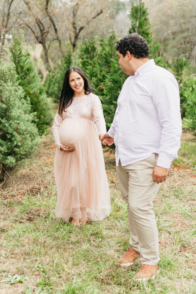 A cozy tree farm family photography session in Georgia, featuring a family posing among lush evergreens during golden hour.