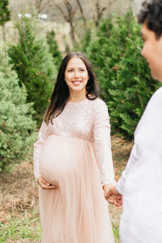 A cozy tree farm family photography session in Georgia, featuring a family posing among lush evergreens during golden hour.