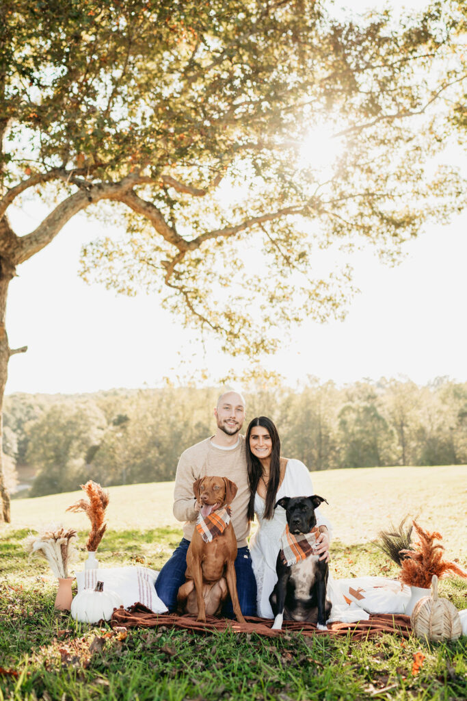 Caitlin and Kyle’s fall maternity session at a park in Flowery Branch, Georgia, featuring autumn foliage and a maternity picnic setup