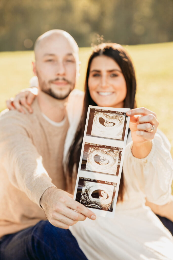 Caitlin and Kyle’s fall maternity session at a park in Flowery Branch, Georgia, featuring autumn foliage and a maternity picnic setup