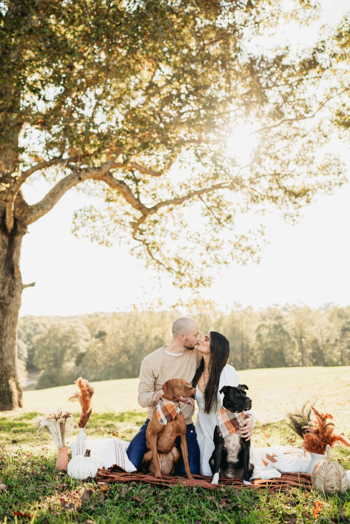 Caitlin and Kyle’s fall maternity session at a park in Flowery Branch, Georgia, featuring autumn foliage and a maternity picnic setup