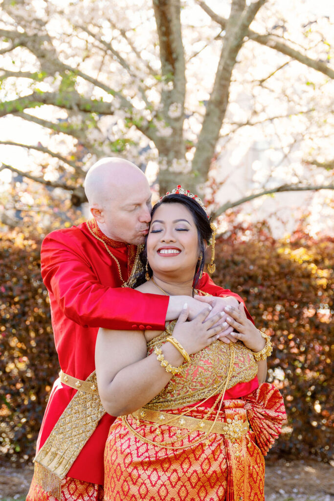 A beautiful Cambodian wedding in Atlanta featuring traditional gold attire and cherry blossom backdrops