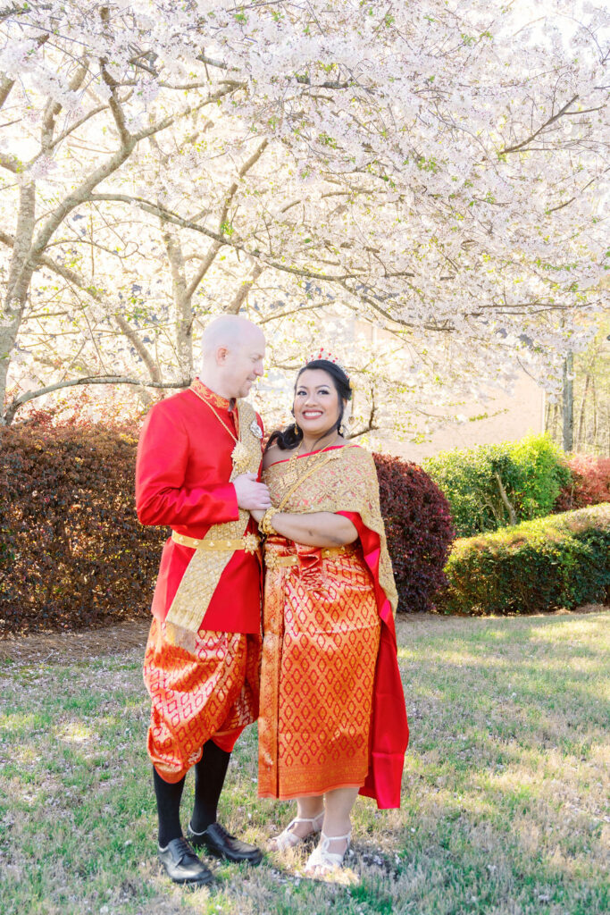 A beautiful Cambodian wedding in Atlanta featuring traditional gold attire and cherry blossom backdrops